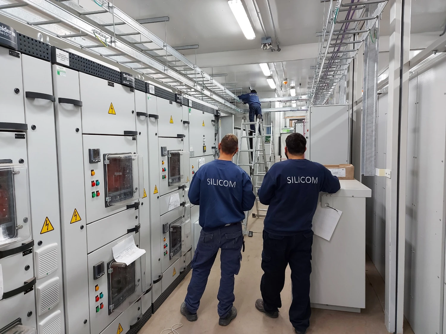 Técnicos de SILICOM trabajando dentro de una sala eléctrica